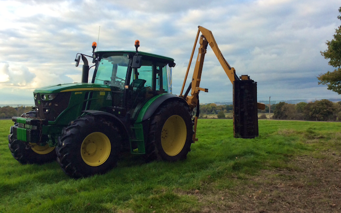 Belsham farming with Hedge cutter at United Kingdom