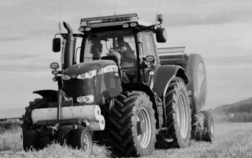 Mains of allanbuie farmers & contractors with Round baler at United Kingdom