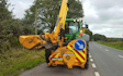 Dan hirst agricultural contractors  with Hedge cutter at United Kingdom